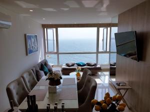 Palmetto Sunset Balcones con vista al mar Cartagena في كارتاهينا دي اندياس: غرفة معيشة مع طاولة وإطلالة على المحيط