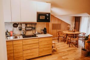 cocina con fregadero y mesa con sillas en VAGABONDO PETIT MAISON, en Caserta