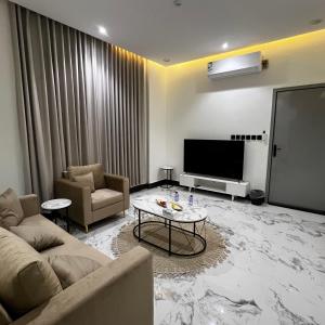 a living room with a couch and a tv at شقة فاخرة بغرفة نوم وصالة 10 Luxury APT in Riyadh