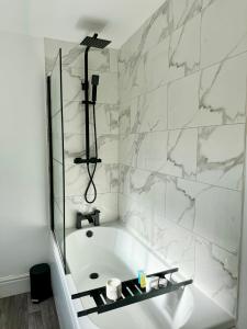 a white bathroom with a tub and a shower at NEW Unique 4 Bed Families Contractors 靠近唐人街 in Nottingham