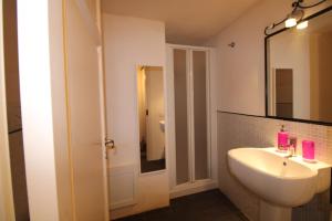 een badkamer met een wastafel en een spiegel bij Suite della Contessa in Castelsardo