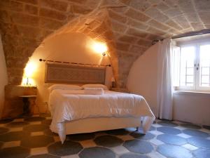 een slaapkamer met een bed met een stenen muur bij Suite della Contessa in Castelsardo