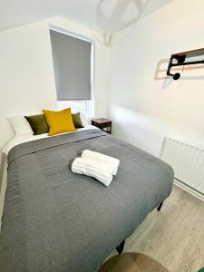 a bedroom with a bed with a towel on it at NEW Unique 4 Bed Families Contractors 靠近唐人街 in Nottingham