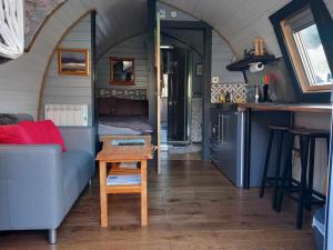 a room with a couch and a table in a tiny house at Riverside Pod, West Highland Way Holidays in Kinlochleven