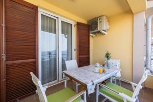 a dining room with a table and chairs at BELLAVISTA apartman Punta in Veli Lošinj