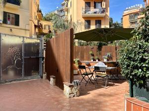 un patio con sombrilla y una mesa con sillas en Eleonora House, en Roma