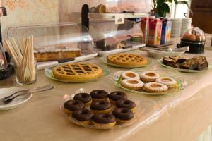 a table topped with different types of donuts and waffles at Albergo San Lorenzo in Grosseto