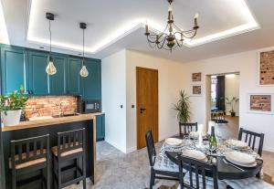 a kitchen and dining room with green cabinets and a table and chairs at Apartament „Nad Ratuszem” in Częstochowa