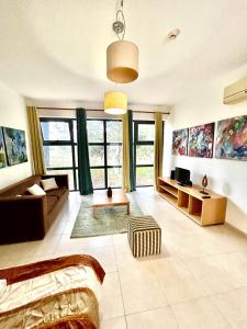 a living room with a couch and some windows at SR Palmela Village Studios II in Quinta do Anjo