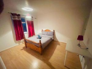 a small bedroom with a bed with red curtains at Double Room near Canary Wharf 28 in London