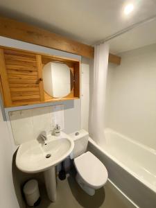 a bathroom with a sink and a toilet and a tub at HOTEL de la PLAGE in Wissant