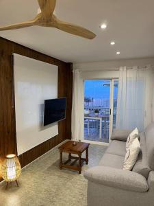 uma sala de estar com um sofá e uma televisão de ecrã plano em Apartamentos Costa Blanca em Playa de Gandia