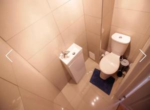 a white bathroom with a toilet and a sink at Double Room near Canary Wharf 28 in London