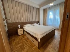 a bedroom with a bed and a window at Apartments 28 in Podgorica