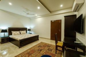 a bedroom with a bed and a flat screen tv at Palm 34 in Jaipur