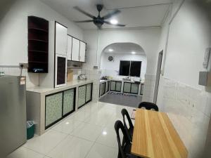 a large kitchen with a table and a dining room at Peach Villa @ Putatan in Kota Kinabalu