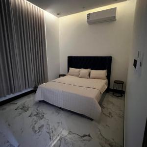 una camera con un letto bianco e una finestra di شقة فاخرة بغرفة نوم وصالة 10 Luxury APT a Riyad