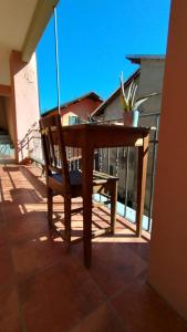 una mesa de madera y una silla en el balcón en La Locanda di Campagna a Guardabosone, 