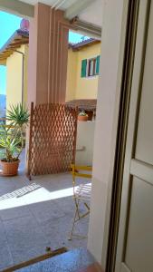 uma porta para uma varanda com uma cadeira numa casa em La Locanda di Campagna a Guardabosone 
