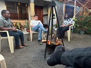 a group of people sitting in chairs around a fire at Safari villa in Arusha