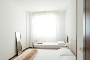 1 Schlafzimmer mit 2 Betten und einem Spiegel in der Unterkunft 54 Bilocale con ampio Terrazzo a 50 metri dal mare in Lignano Sabbiadoro