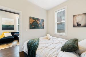 a bedroom with a bed and a living room at Stylish 2 BDR Coach House Steps From The Lake in Chicago