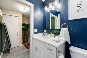 uma casa de banho com um lavatório branco e uma parede azul em Stylish 2 BDR Coach House Steps From The Lake em Chicago