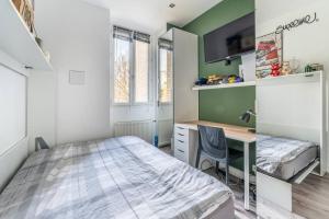 een kleine slaapkamer met een bed en een bureau bij luxueux appartement haussmannien in Saint-Mandé