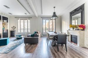 een woonkamer met een tafel en stoelen en een open haard bij luxueux appartement haussmannien in Saint-Mandé