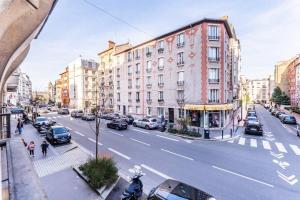 een uitzicht op een straat met auto's en gebouwen bij luxueux appartement haussmannien in Saint-Mandé