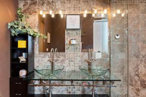 een badkamer met 2 glazen wastafels en een spiegel bij Zen Oasis of Elegance: Expansive Executive Home in Chicago