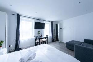 a bedroom with a bed and a couch and a table at King's Cross Cosy Corner Pass the Keys in London