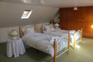 Un dormitorio con dos camas y una mesa. en Katie's Town House, en Cahersiveen