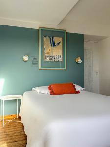 a bedroom with a white bed and a blue wall at HOTEL de la PLAGE in Wissant