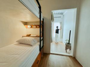 a man looking out the window of a bedroom at De Nata in Labuan Bajo