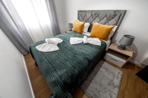 Un dormitorio con una cama verde con dos corbatas de lazo. en Quartos da Tia Laura, en Nazaré