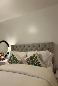 a bed with white pillows with a large headboard at STARS LUXURY HOME in London