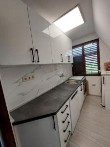 a kitchen with white cabinets and a counter top at Vikendica Uvac in Priboj