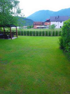 ein Grasfeld mit einem Zaun und einem Gebäude in der Unterkunft Vikendica Uvac in Priboj