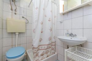 ein Badezimmer mit Toilette, Waschbecken und Duschvorhang in der Unterkunft Studio Apartments Klara and Rio in Stomorska