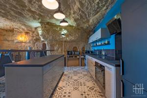 eine Bar in einer Höhle mit einer Steinmauer in der Unterkunft La Troglo - Maison typique de notre région in Vouvray