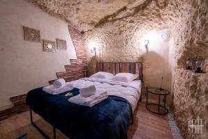 ein Schlafzimmer mit einem Bett in einer Steinmauer in der Unterkunft La Troglo - Maison typique de notre région in Vouvray