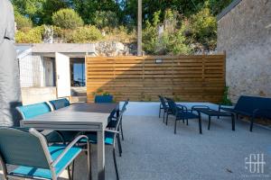 eine Terrasse mit Tischen und Stühlen und einem Holzzaun in der Unterkunft La Troglo - Maison typique de notre région in Vouvray