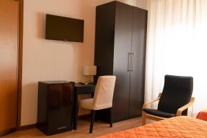 グロッセートにあるAlbergo San Lorenzoのベッドルーム1室(デスク、キャビネット、椅子2脚付)