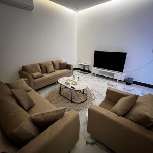 un soggiorno con 2 divani e una TV di شقة فاخرة بغرفة نوم وصالة 10 Luxury APT a Riyad