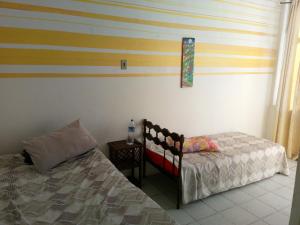 1 dormitorio con cama y almohada junto a una ventana en Pun pon pelô en Salvador