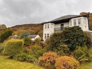 a large white house on top of a hill at Lochranza Country Inn in Lochranza