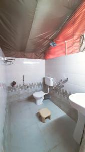a bathroom with a toilet and a sink at Kodom Bari Retreat, Kaziranga in Kāziranga