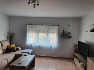a living room with a couch and a window at Piso da Charca in Fisterra