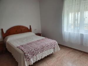 a bedroom with a bed and a window at Piso da Charca in Fisterra